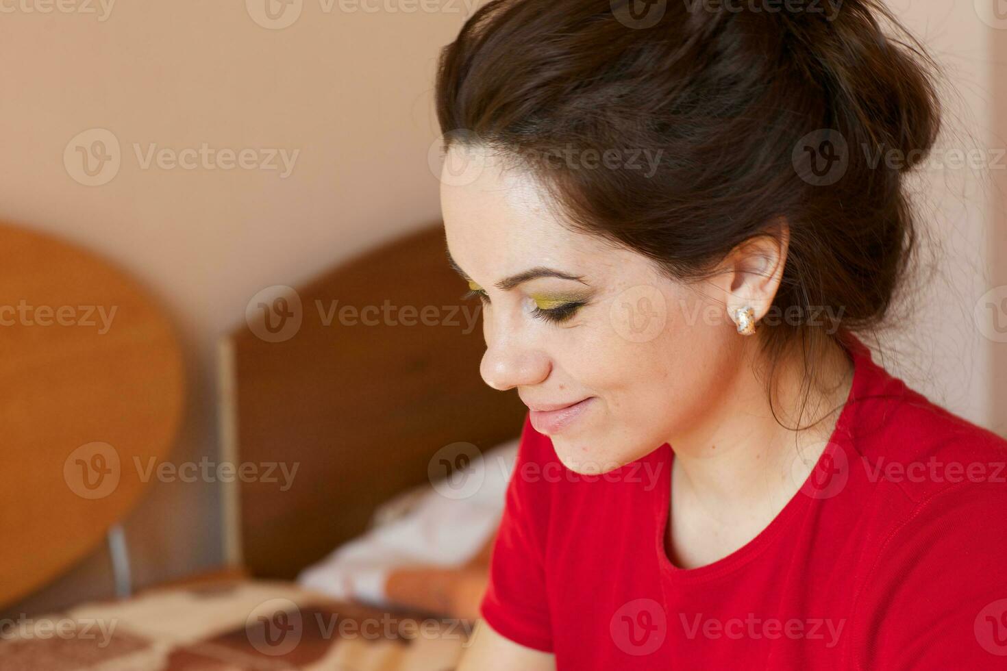 Young lady is applying make up on her face. Closeup photo