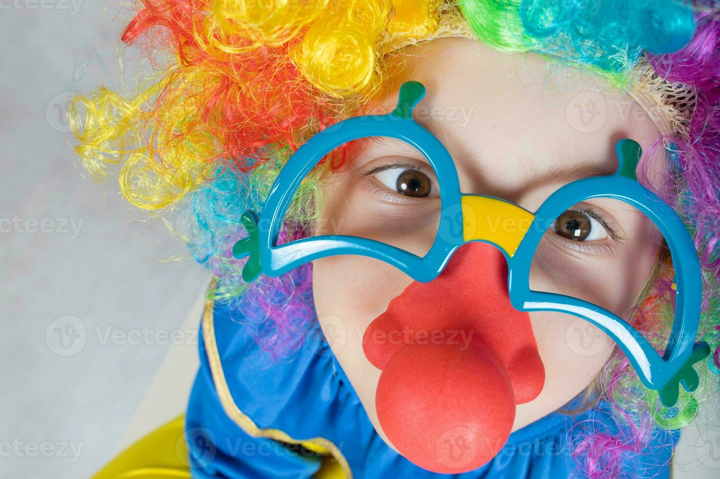 Boy of five years dressed in the costume of a clown and funny eyeglasses with red nose. photo