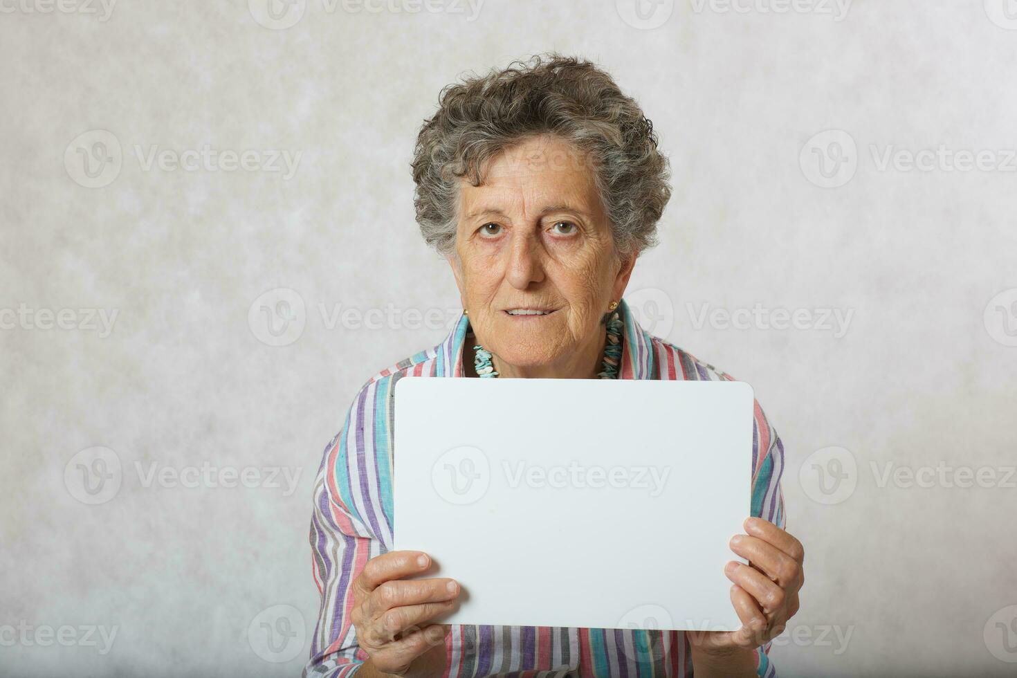 Old woman with a piece of carton paper photo
