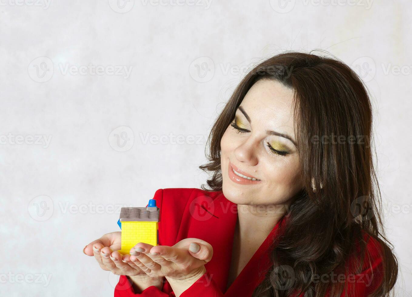 A lady keeps a small rubber house photo