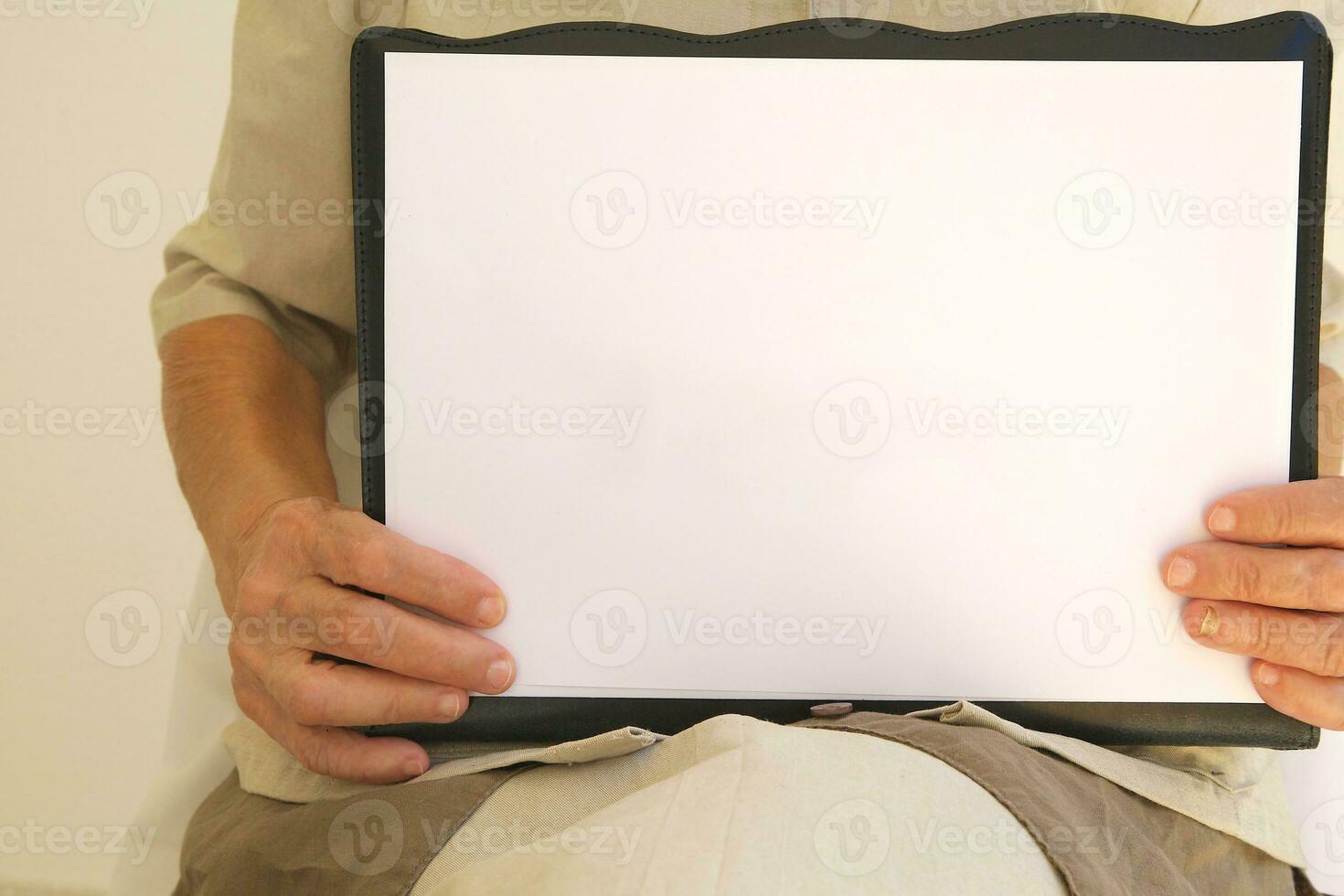 A white sheet of a paper in the hands of senior woman photo