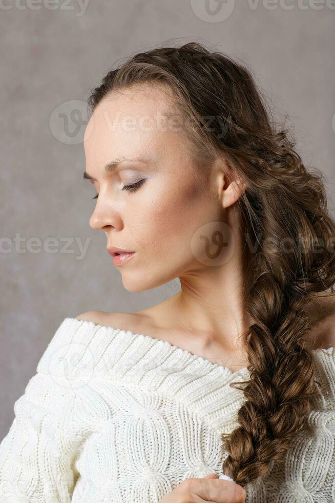 Young lady dressed in knitted sweater. Closeup photo