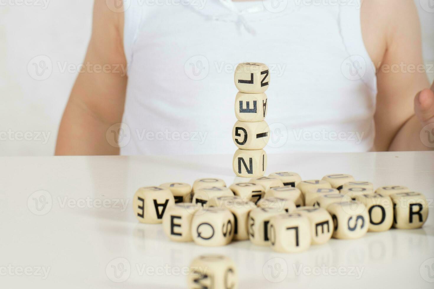 Small girl composes words from letters. Closeup photo