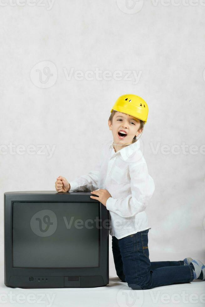 Boy of seven years old wants to destroy an old TV. photo