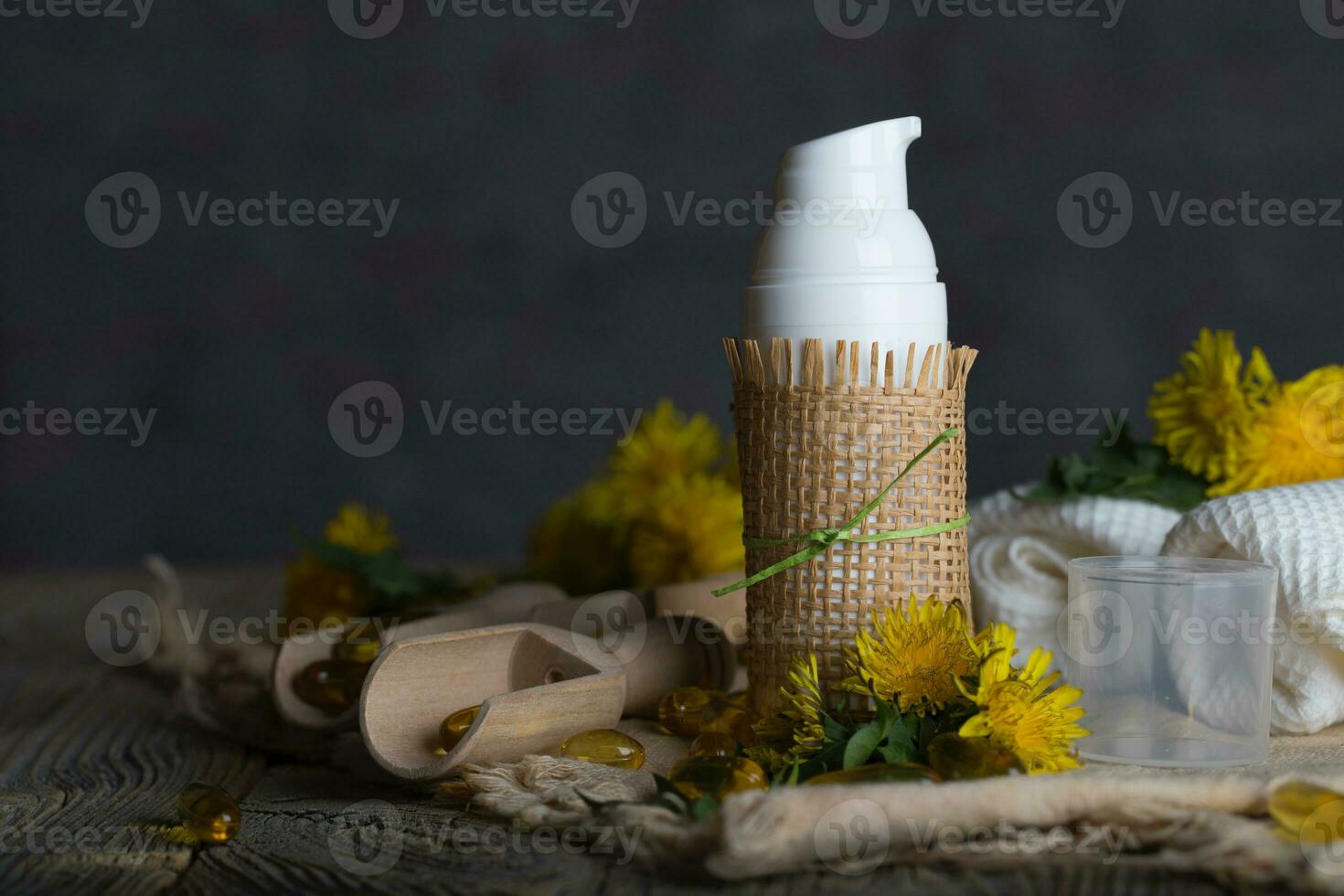 Cream with dandelion extract in a white plastic bottle on a wooden surface. photo