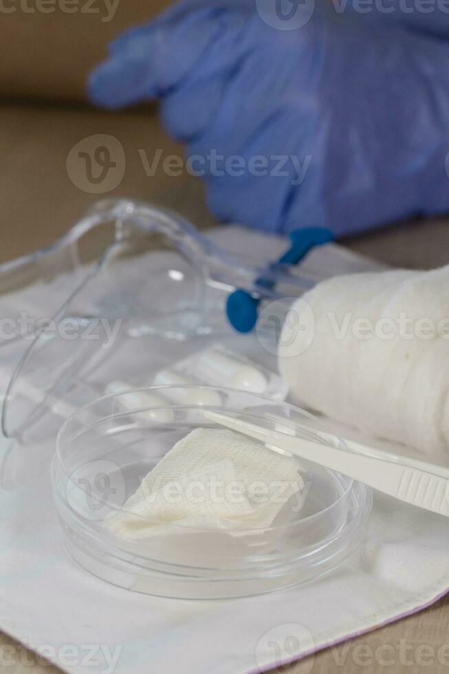 Sterile cotton napkin and plastic pincers in front of the laboratory technician. photo