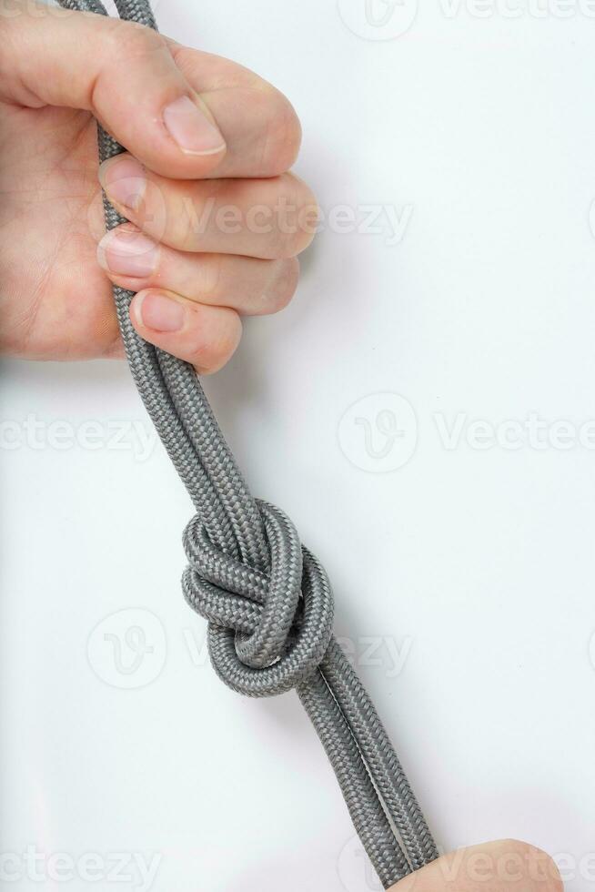 Rope with a simple knot on a white surface. Closeup. photo