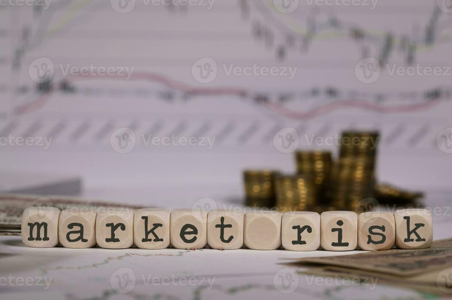 Words MARKET RISK composed of wooden letter. Stacks of coins in the background. photo