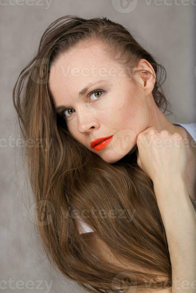 Sexy young lady with orange lipstick. Closeup photo