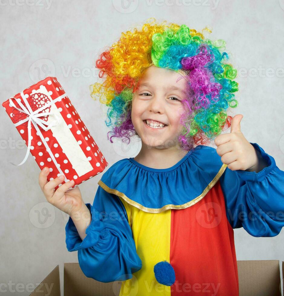 Boy of five years dressed in the costume of a clown with a gift. photo