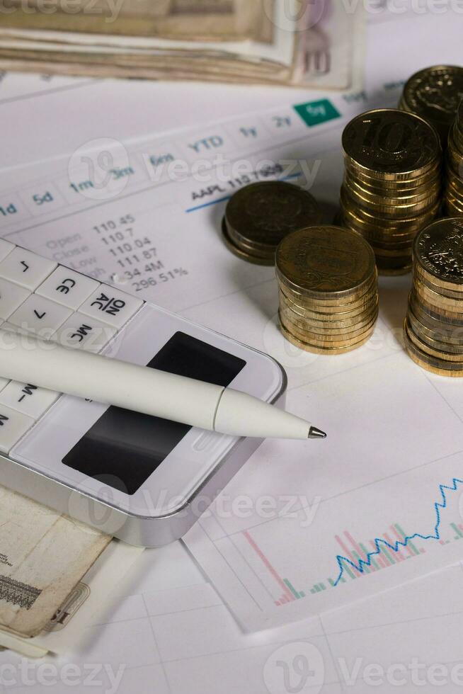 Pen on calculator. Coins of ten roubles in the background. photo