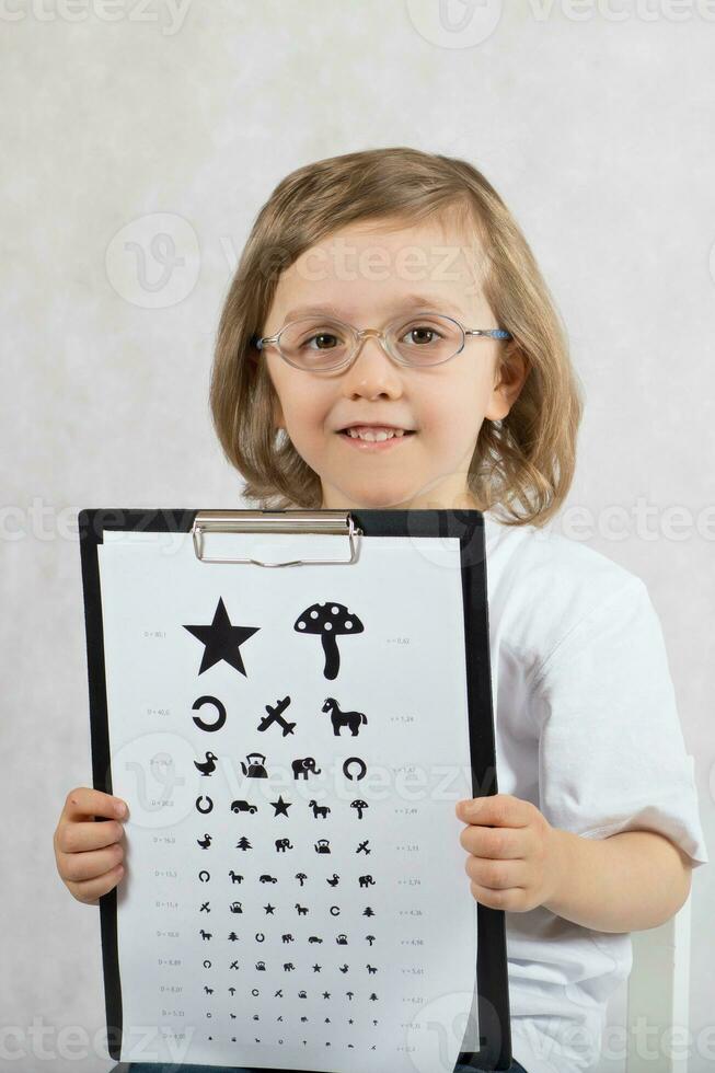 Ophtalmologist checks vision of 5 years old boy photo