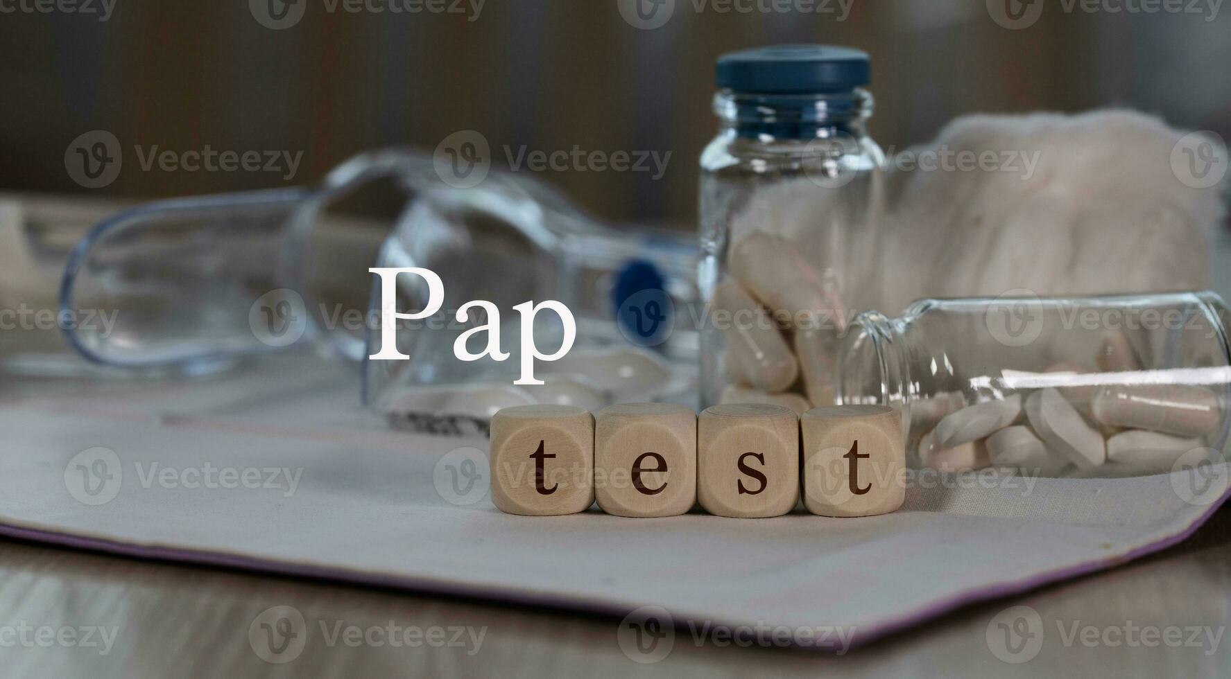 Words PAP TEST composed of wooden dices. Pills, documents and a pen in the background. photo