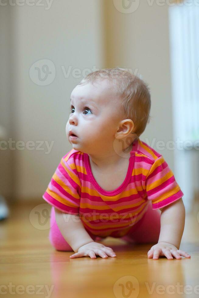 A baby is crawling in a living room photo