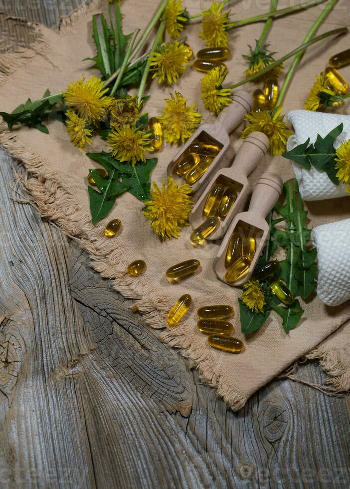 cápsulas blandas de diente de león extraer en de madera cucharas foto