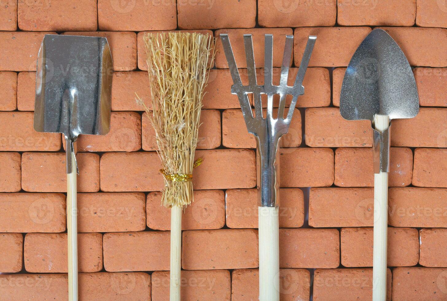 Agricultural tools on a brick wall. Background. photo