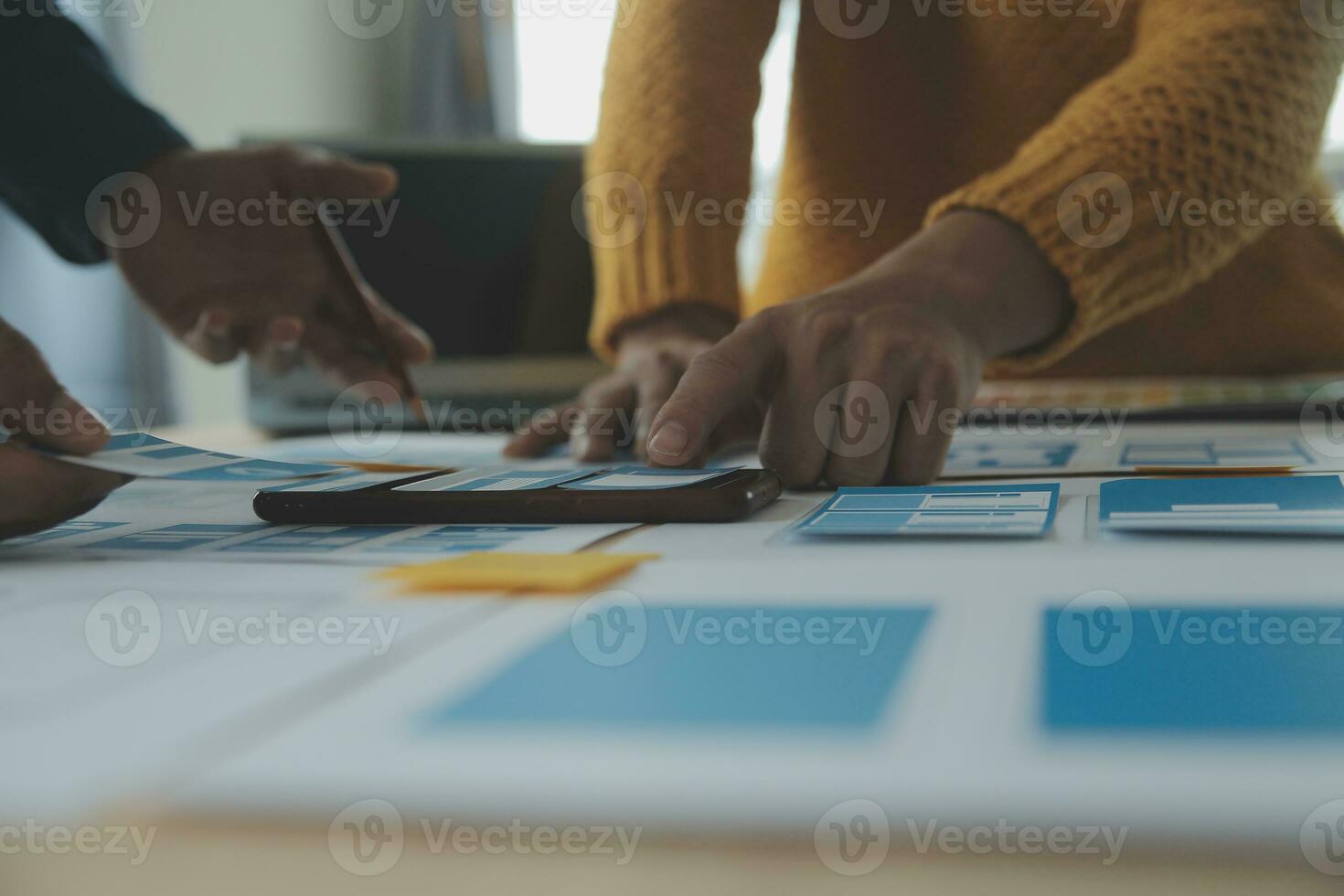 Close up ux developer and ui designer brainstorming about mobile app interface wireframe design on table with customer breif and color code at modern office.Creative digital development agency photo