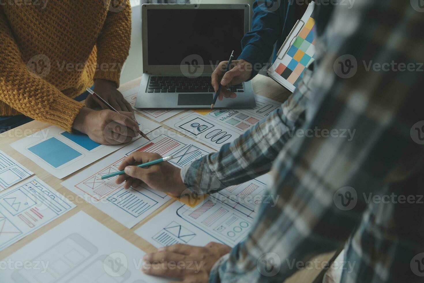 Close up ux developer and ui designer brainstorming about mobile app interface wireframe design on table with customer breif and color code at modern office.Creative digital development agency photo