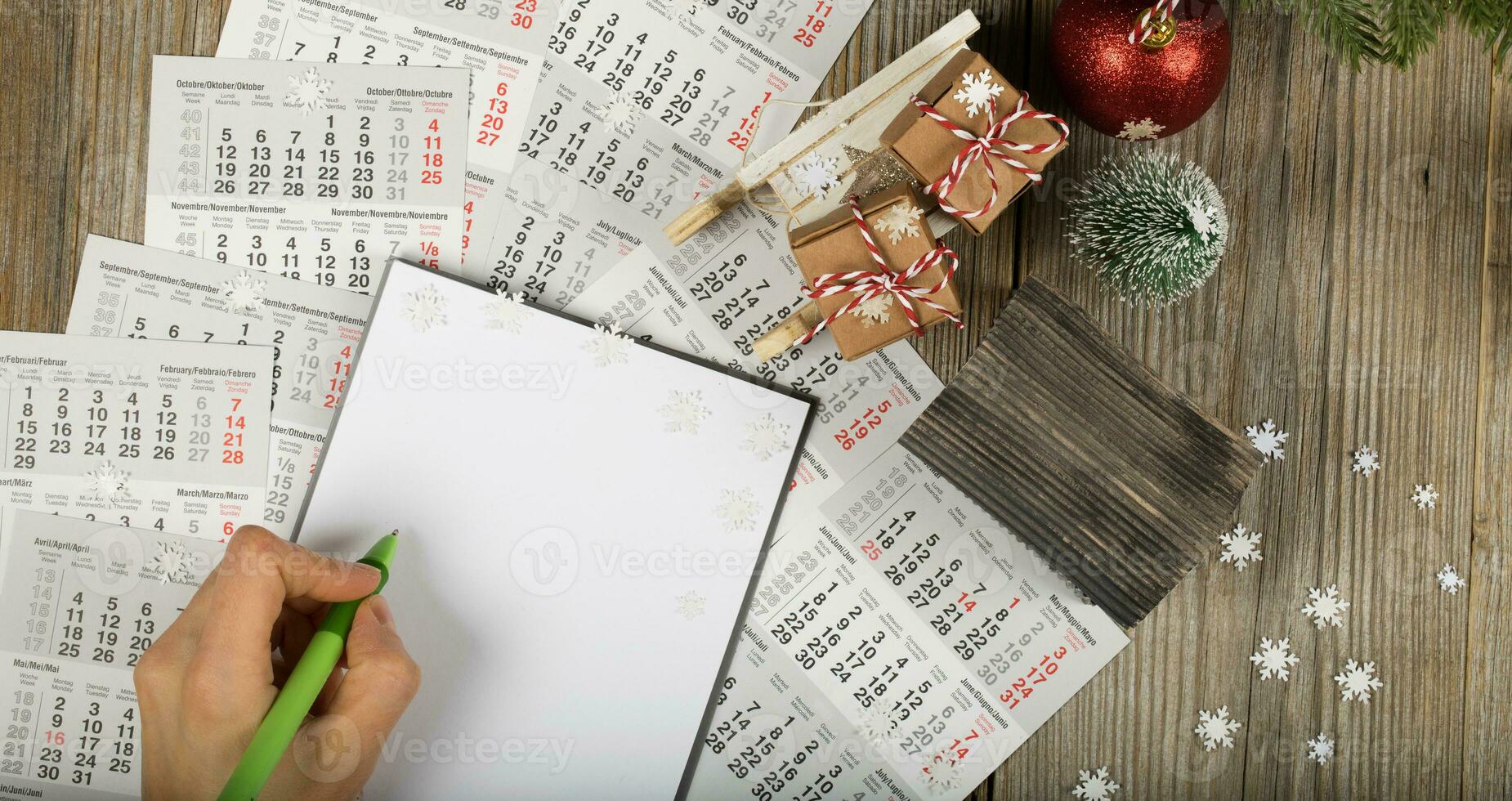 Blank sheet of paper and small paper house with coins on the New Year's background. photo