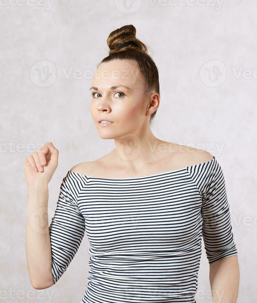 A young woman dressed in a white gray shirt. Free space for a text photo