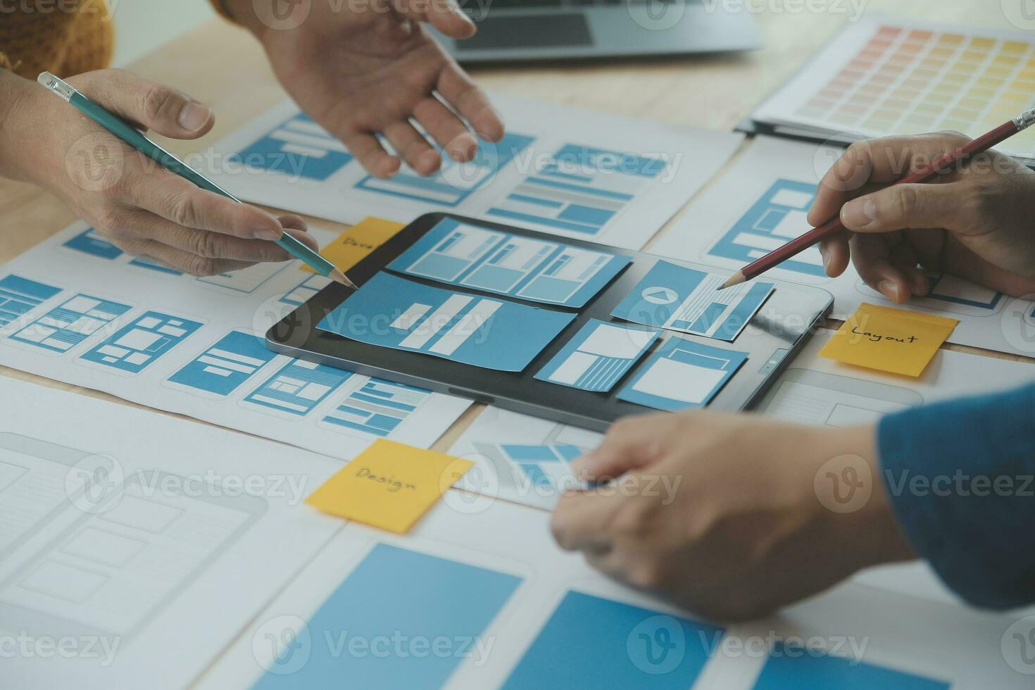 Close up ux developer and ui designer brainstorming about mobile app interface wireframe design on table with customer breif and color code at modern office.Creative digital development agency photo