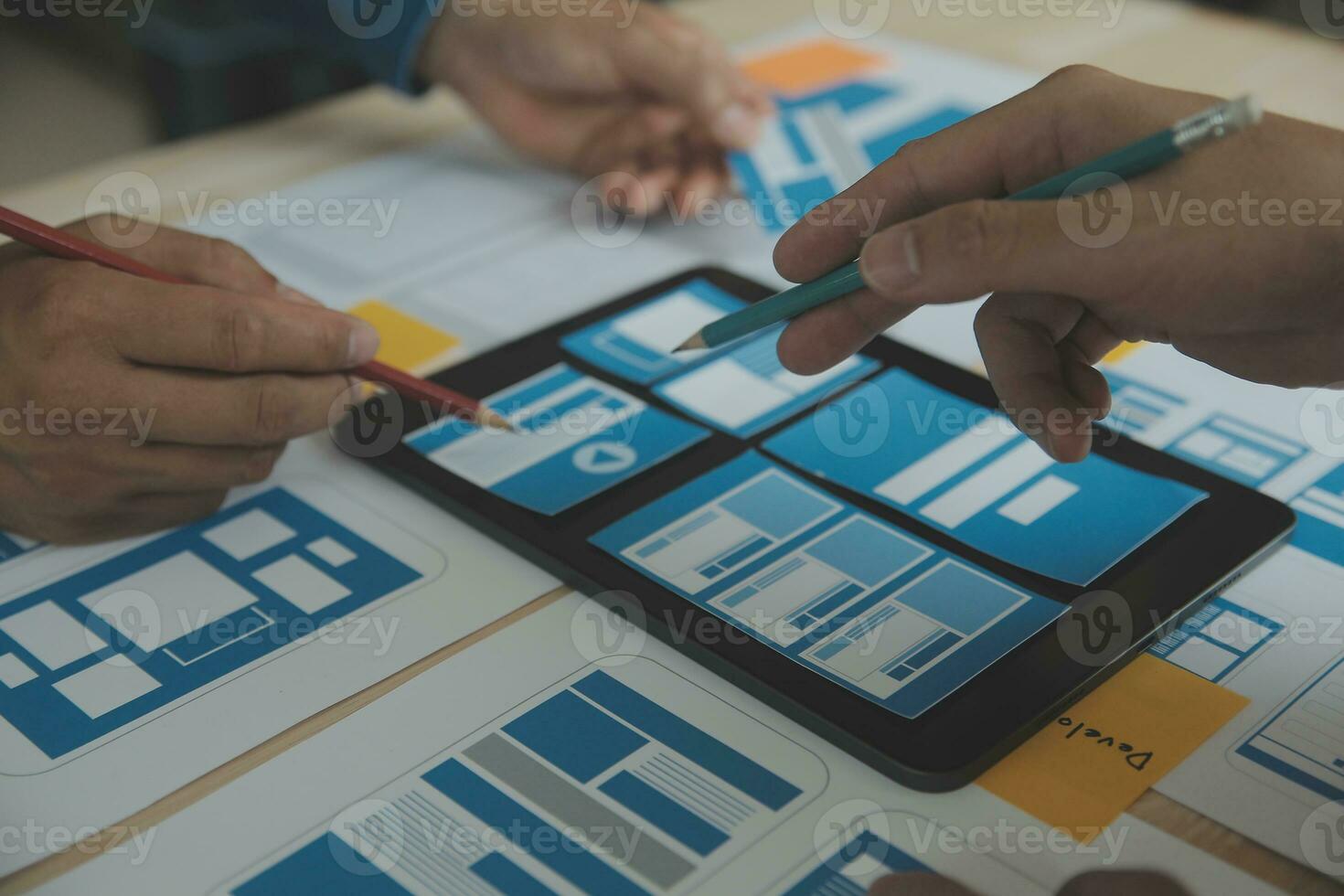 Close up ux developer and ui designer brainstorming about mobile app interface wireframe design on table with customer breif and color code at modern office.Creative digital development agency photo