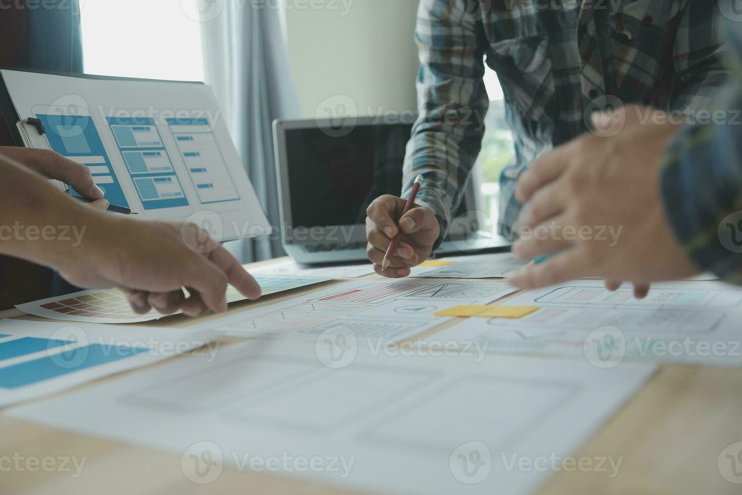 Close up ux developer and ui designer brainstorming about mobile app interface wireframe design on table with customer breif and color code at modern office.Creative digital development agency photo