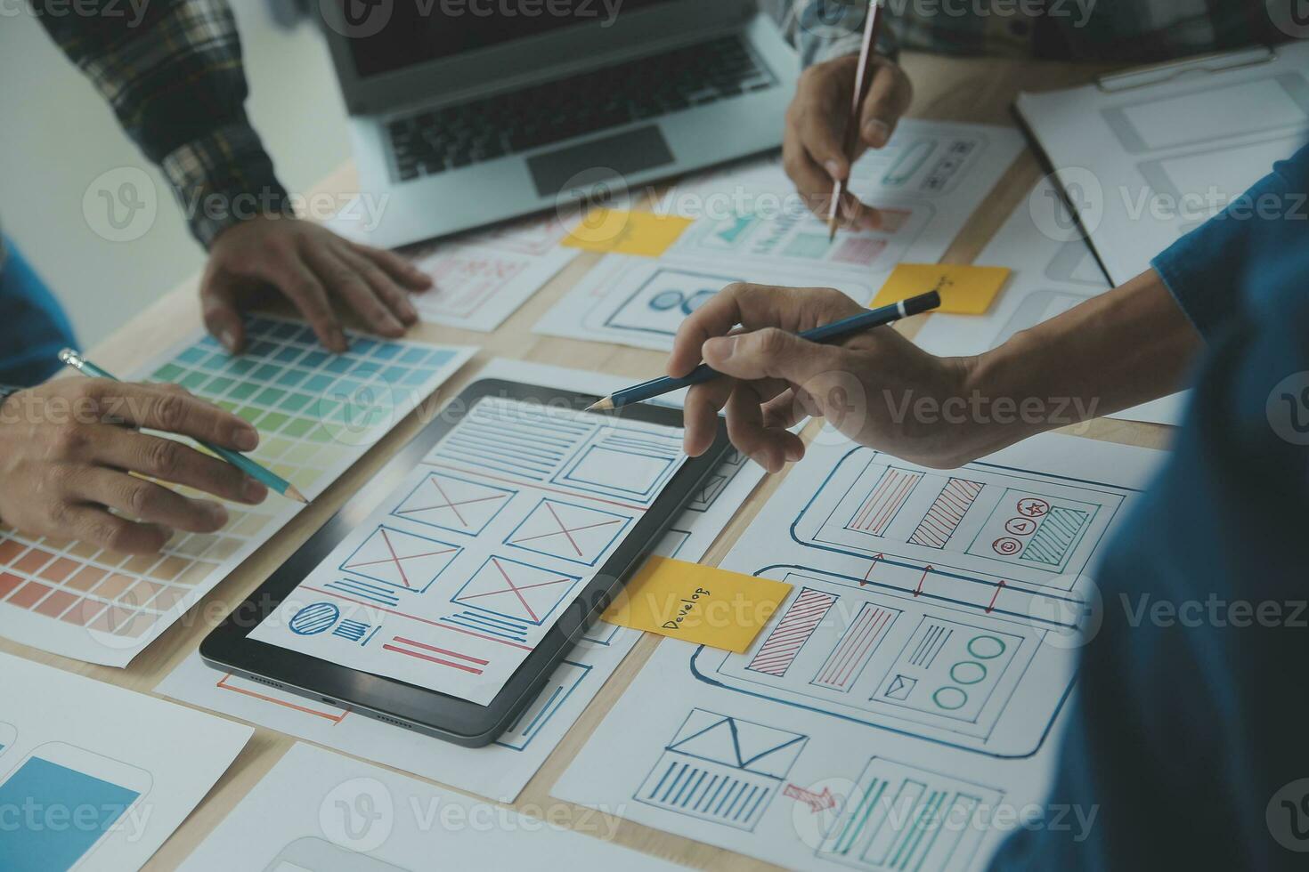 Close up ux developer and ui designer brainstorming about mobile app interface wireframe design on table with customer breif and color code at modern office.Creative digital development agency photo