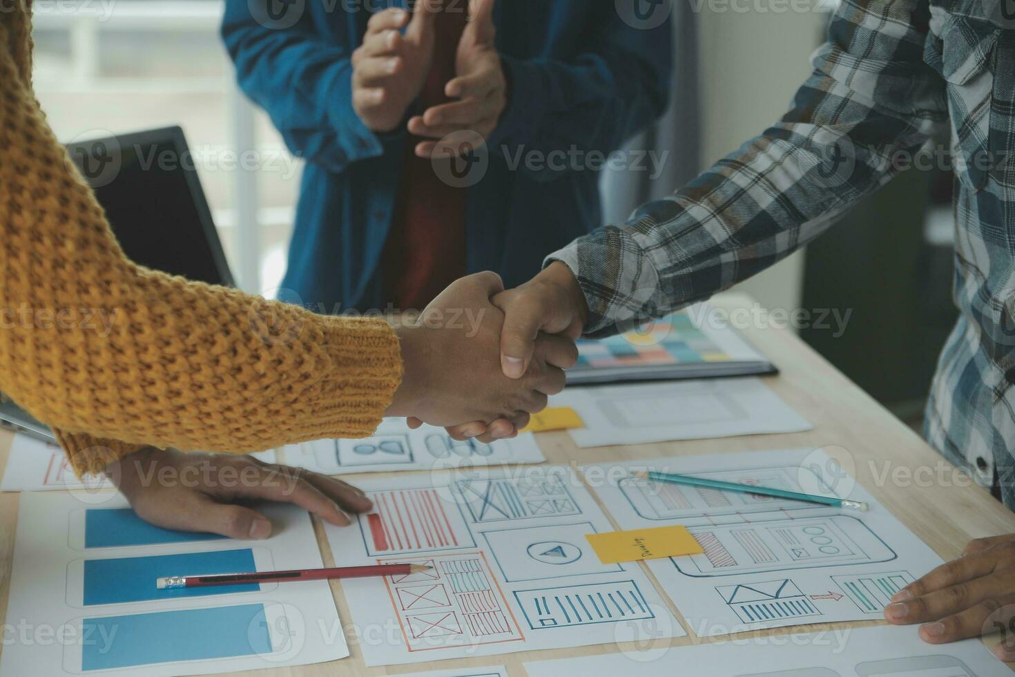 Close up ux developer and ui designer brainstorming about mobile app interface wireframe design on table with customer breif and color code at modern office.Creative digital development agency photo