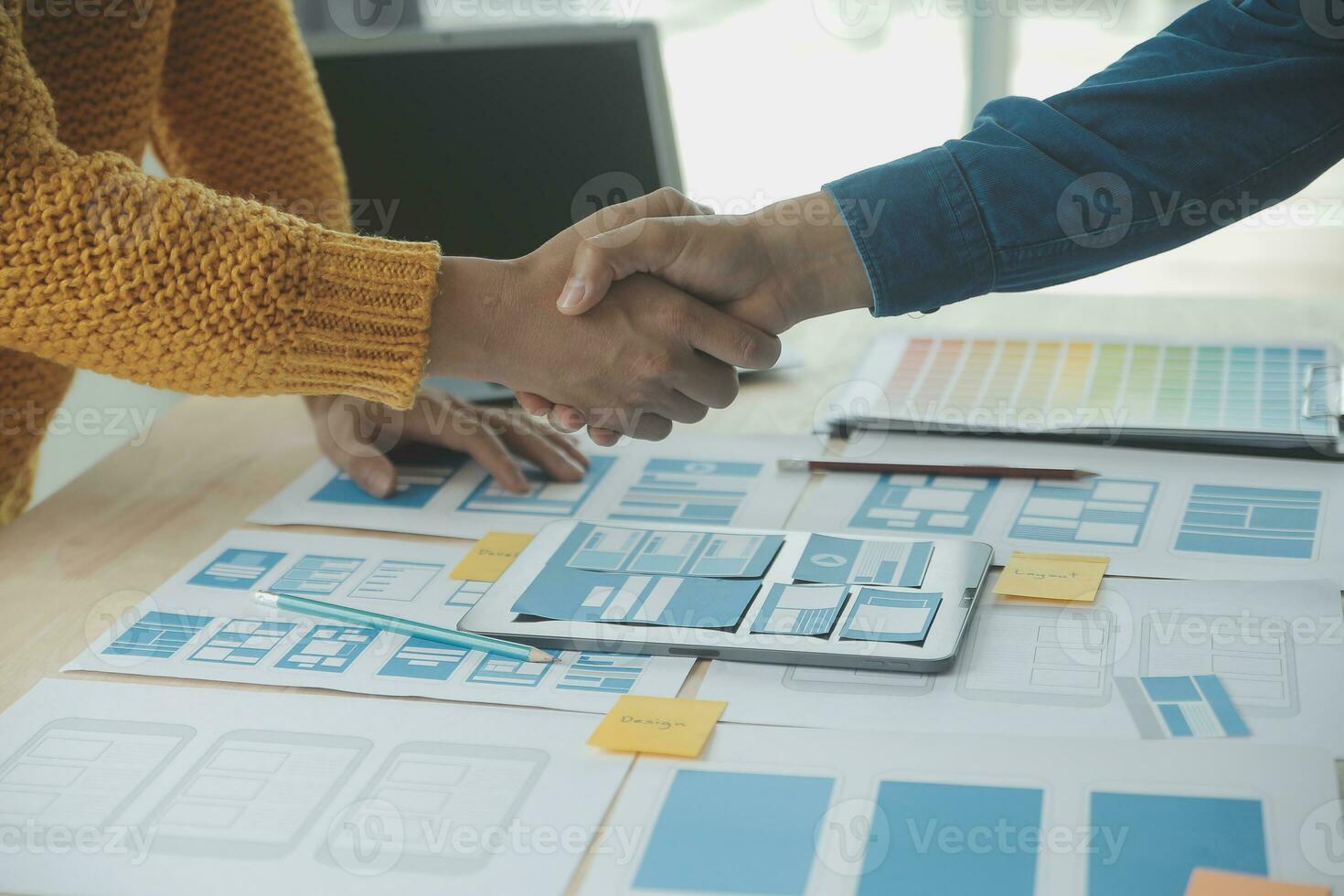 Close up ux developer and ui designer brainstorming about mobile app interface wireframe design on table with customer breif and color code at modern office.Creative digital development agency photo