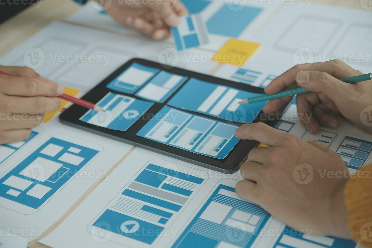 Close up ux developer and ui designer brainstorming about mobile app interface wireframe design on table with customer breif and color code at modern office.Creative digital development agency photo