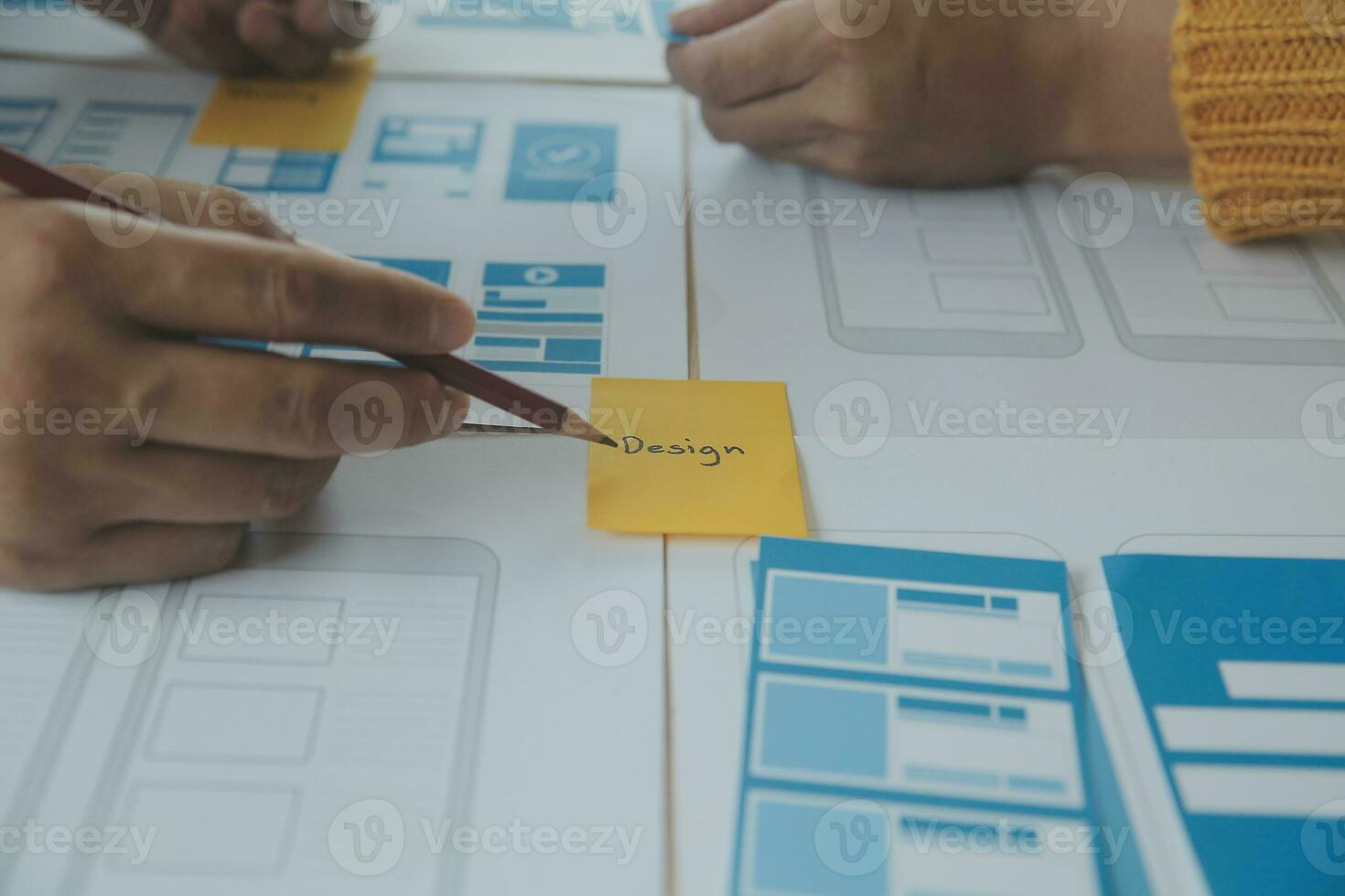 Close up ux developer and ui designer brainstorming about mobile app interface wireframe design on table with customer breif and color code at modern office.Creative digital development agency photo
