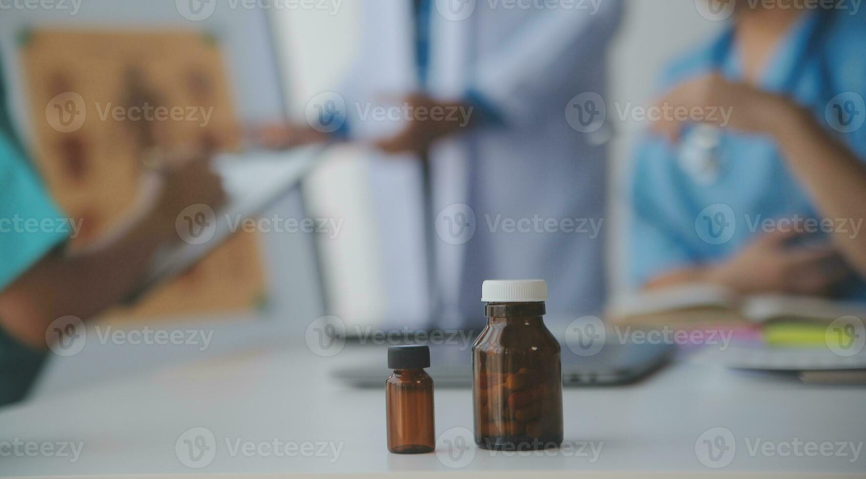 medical team having a meeting with doctors in white lab coats and surgical scrubs seated at a table discussing a patients records,success medical health care, Medicine doctor's working concept photo