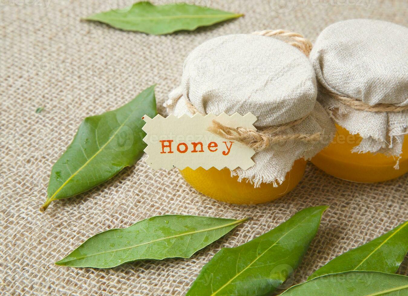 A glass of honey and bay leaves photo