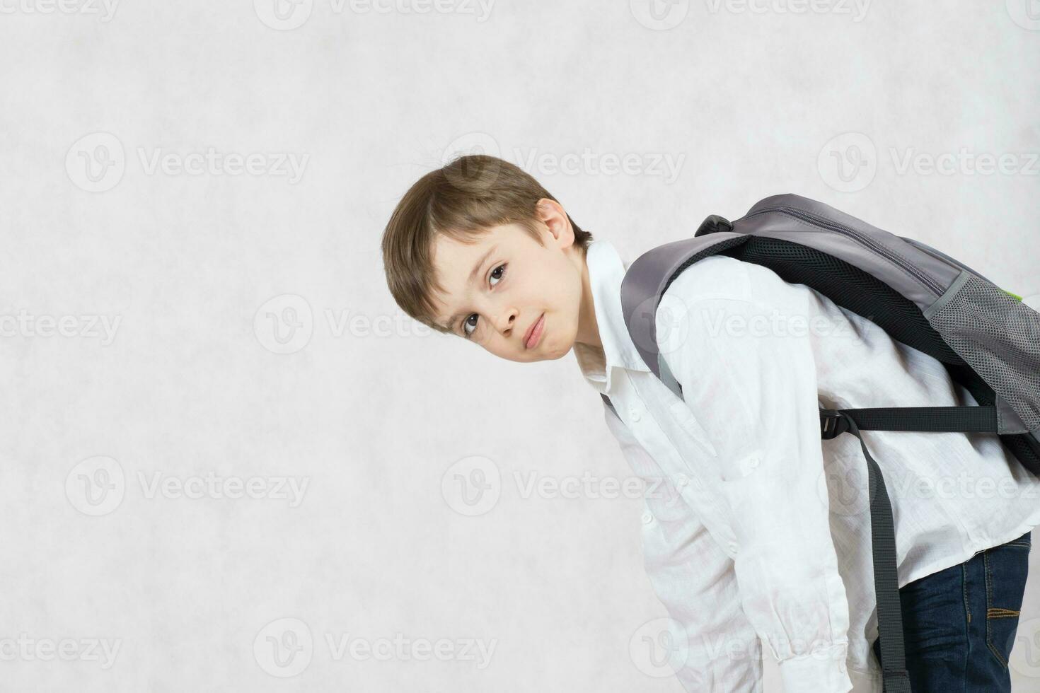 Schoolboy carries his backpack with books on his back. Free space for a text. photo