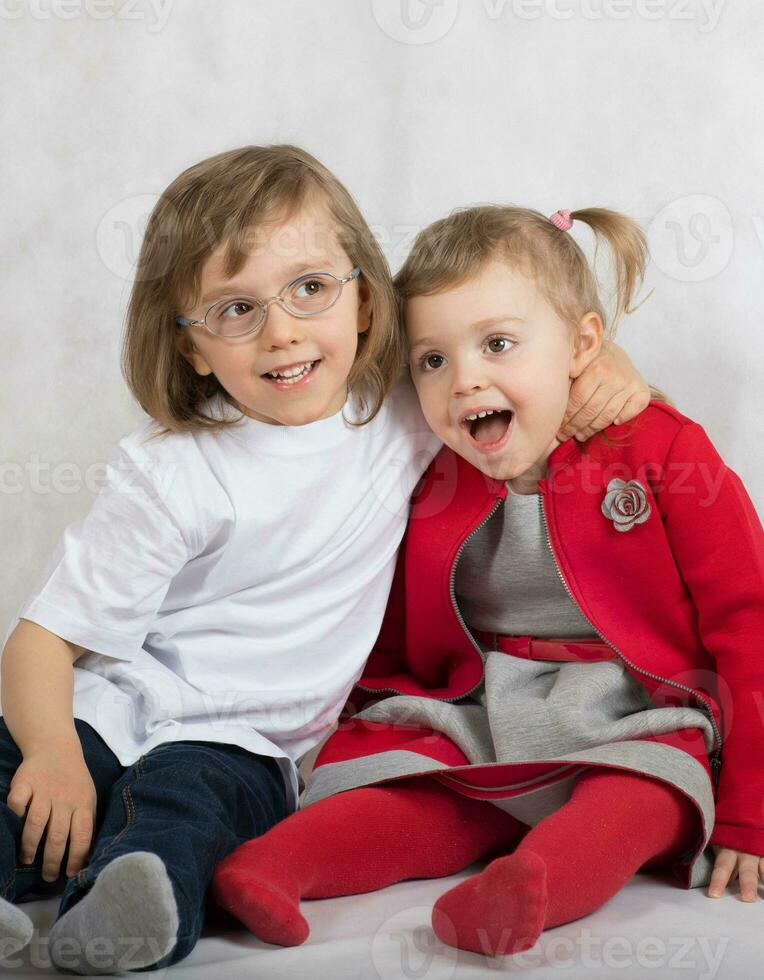 Boy of five years and girl of 2 years are sitting together. photo