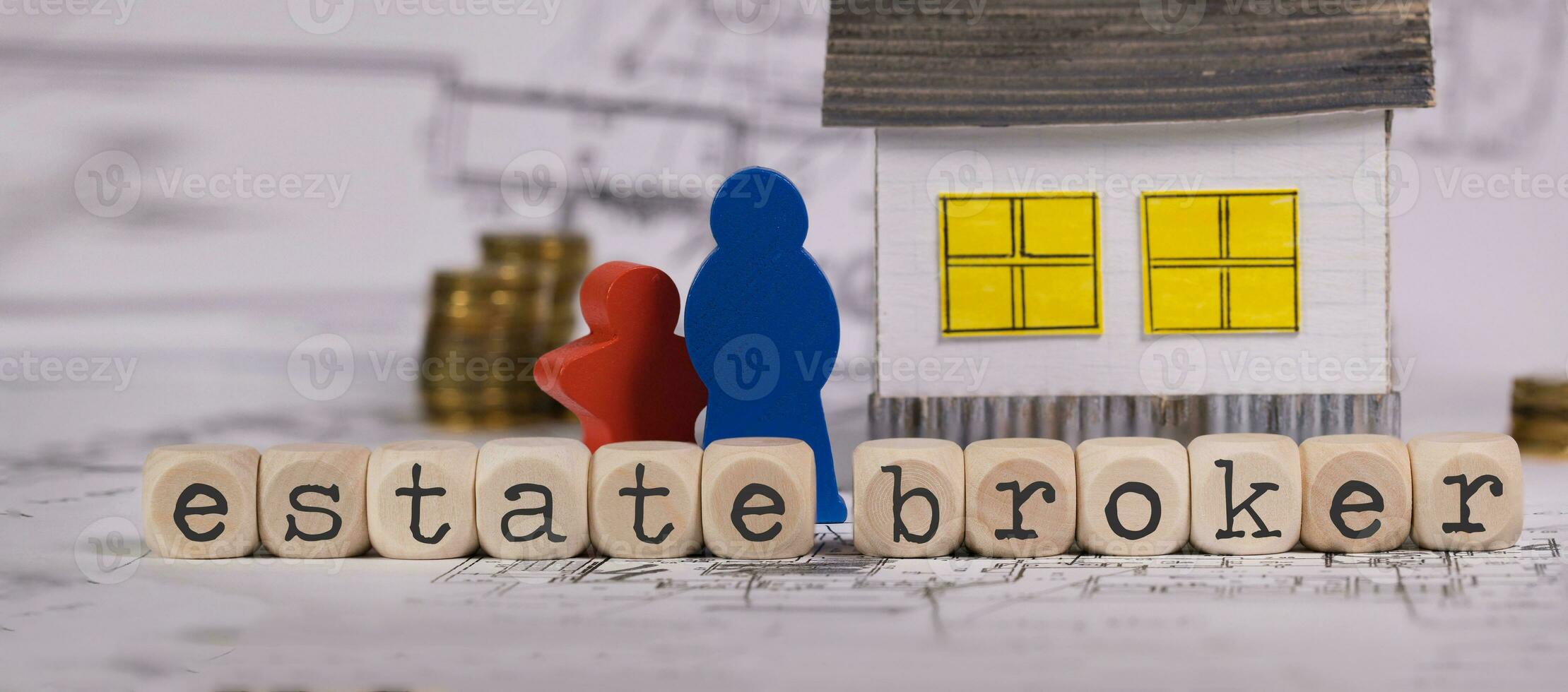 Words ESTATE BROKER composed of wooden letter. Small paper house in the background. photo