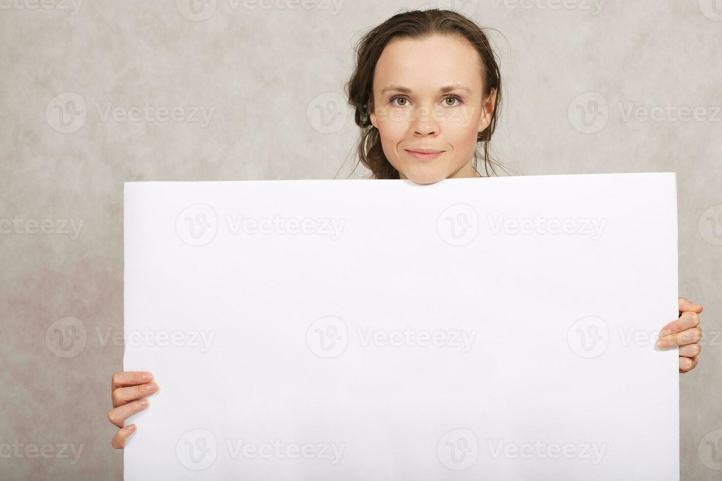 Young lady keeps a white sheet of paper photo