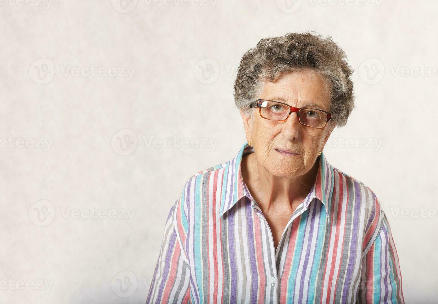 un reflexivo mayor mujer. gris antecedentes foto