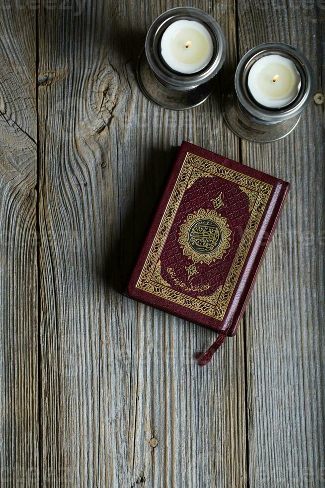 Quran and candles on a wooden surface. photo