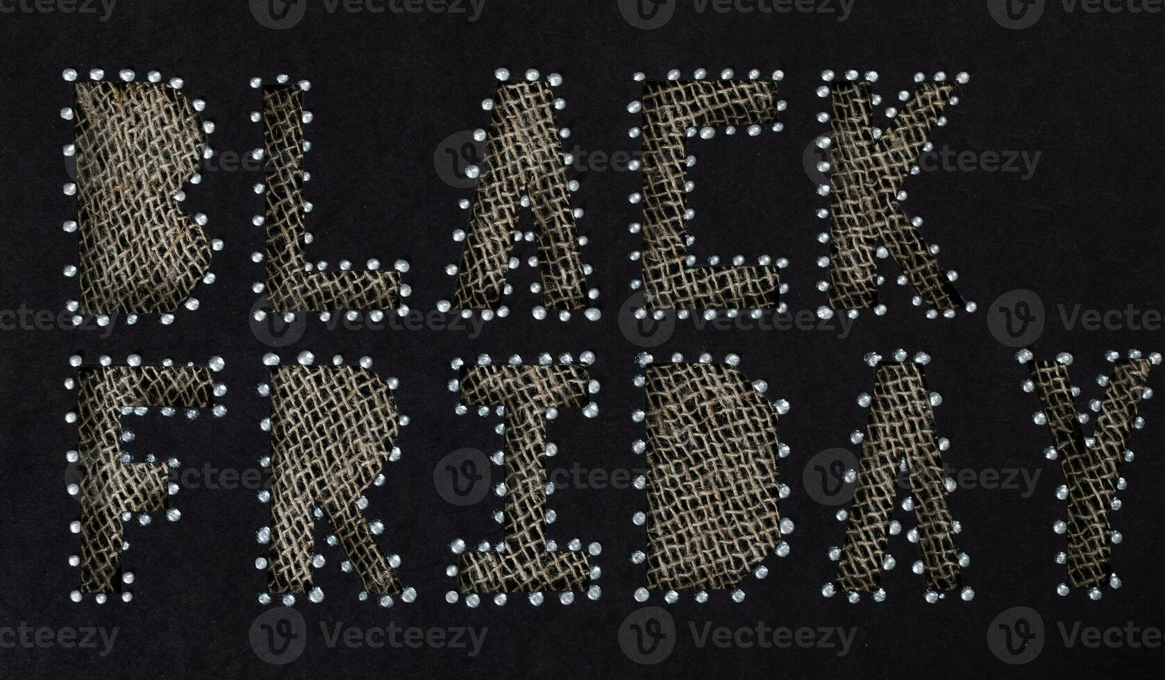 Words BLACK FRIDAY are cut out from black carton paper. photo