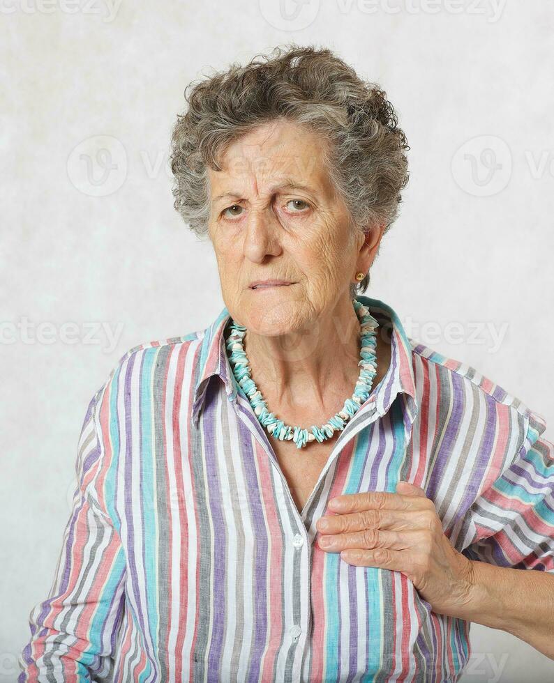 Old woman suffers from a pain in her heart photo