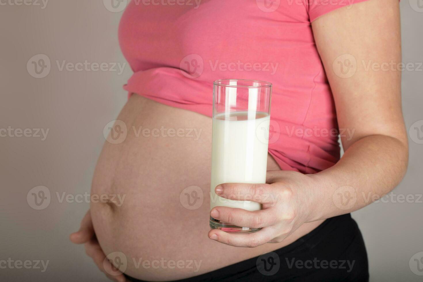 Young pregnant woman keeps a glass of milk. photo