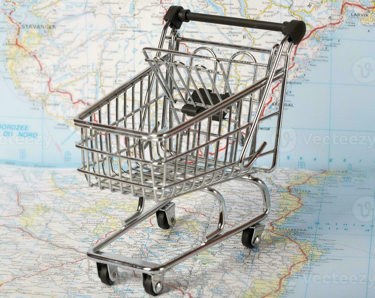 Mini shopping cart on a map. photo