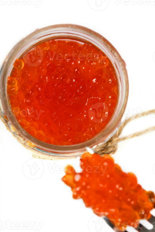 Red caviar in the glass bottle. photo