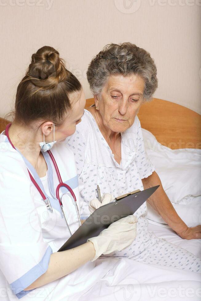 Geriatrician visits a senior woman photo