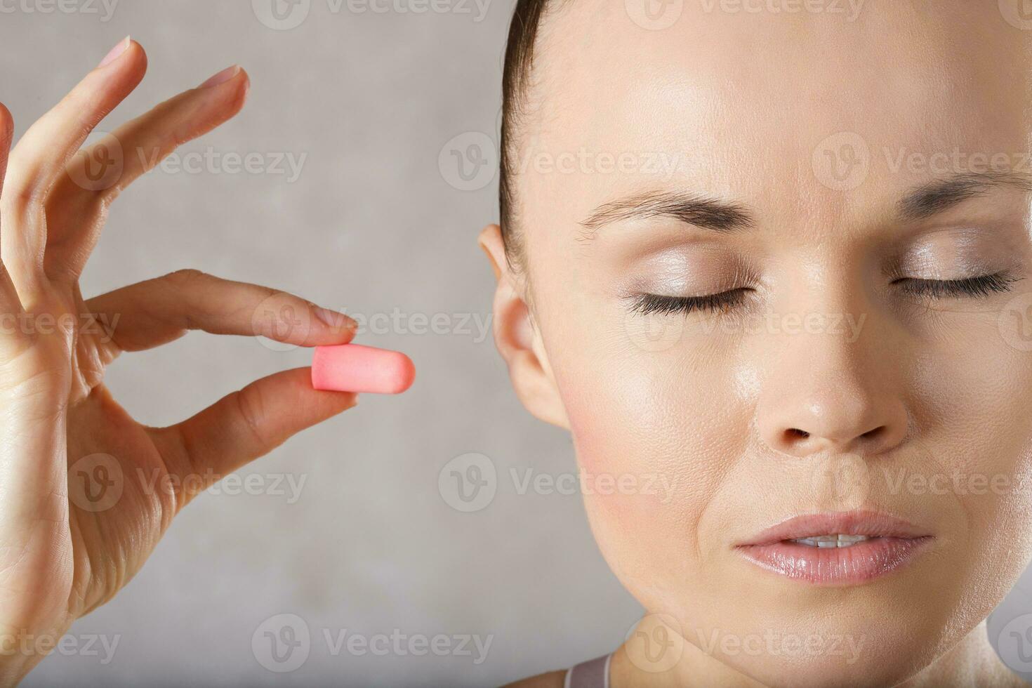 Young woman is introducing earplugs. Closeup. photo