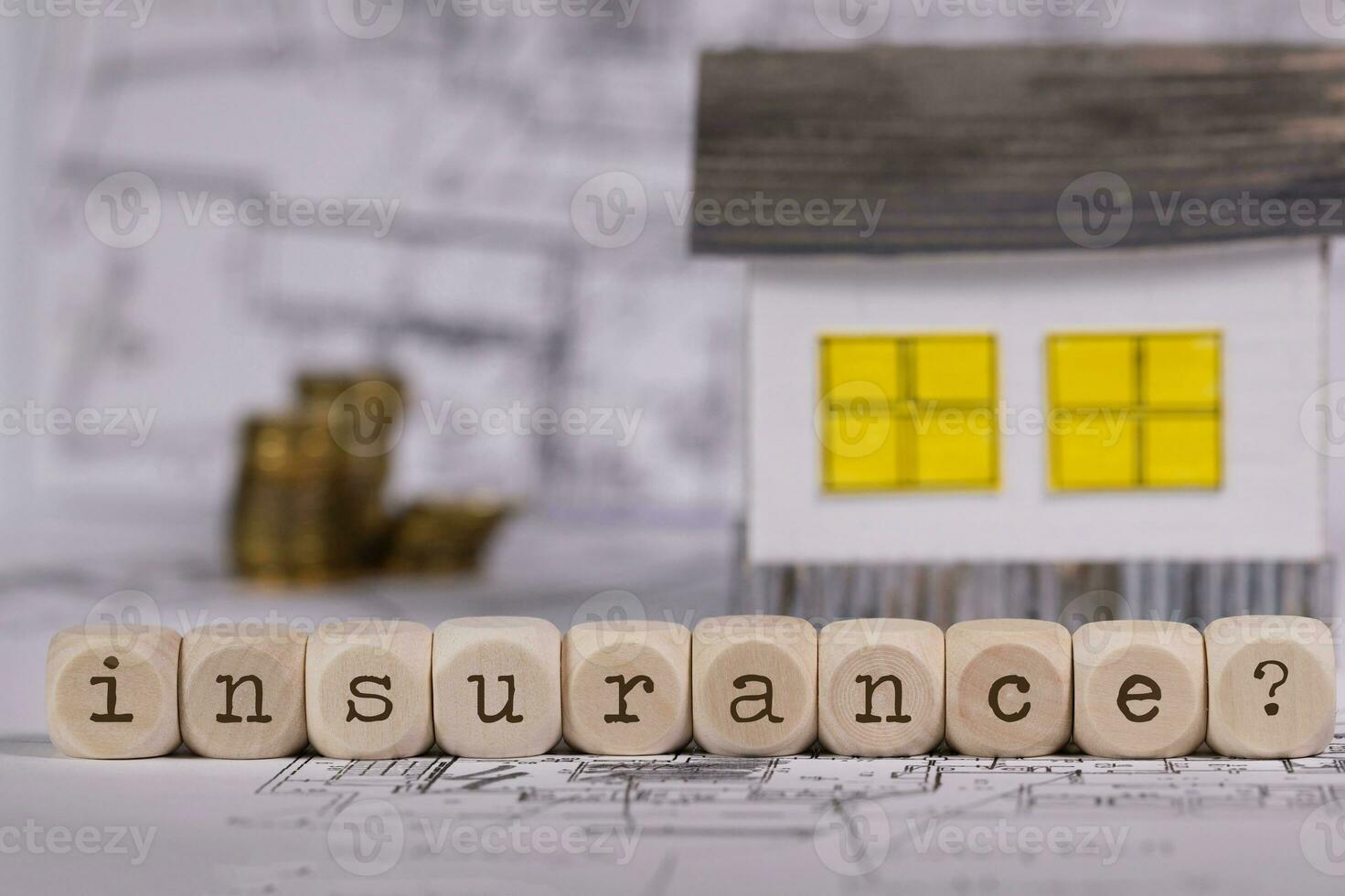 Word INSURANCE composed of wooden letters and question mark.  Small paper house in the background. photo