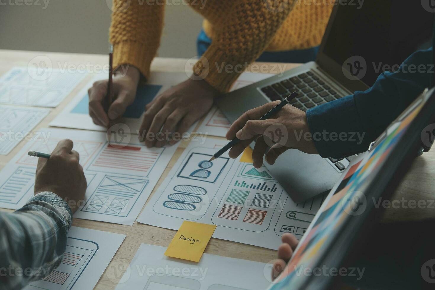 Close up ux developer and ui designer brainstorming about mobile app interface wireframe design on table with customer breif and color code at modern office.Creative digital development agency photo
