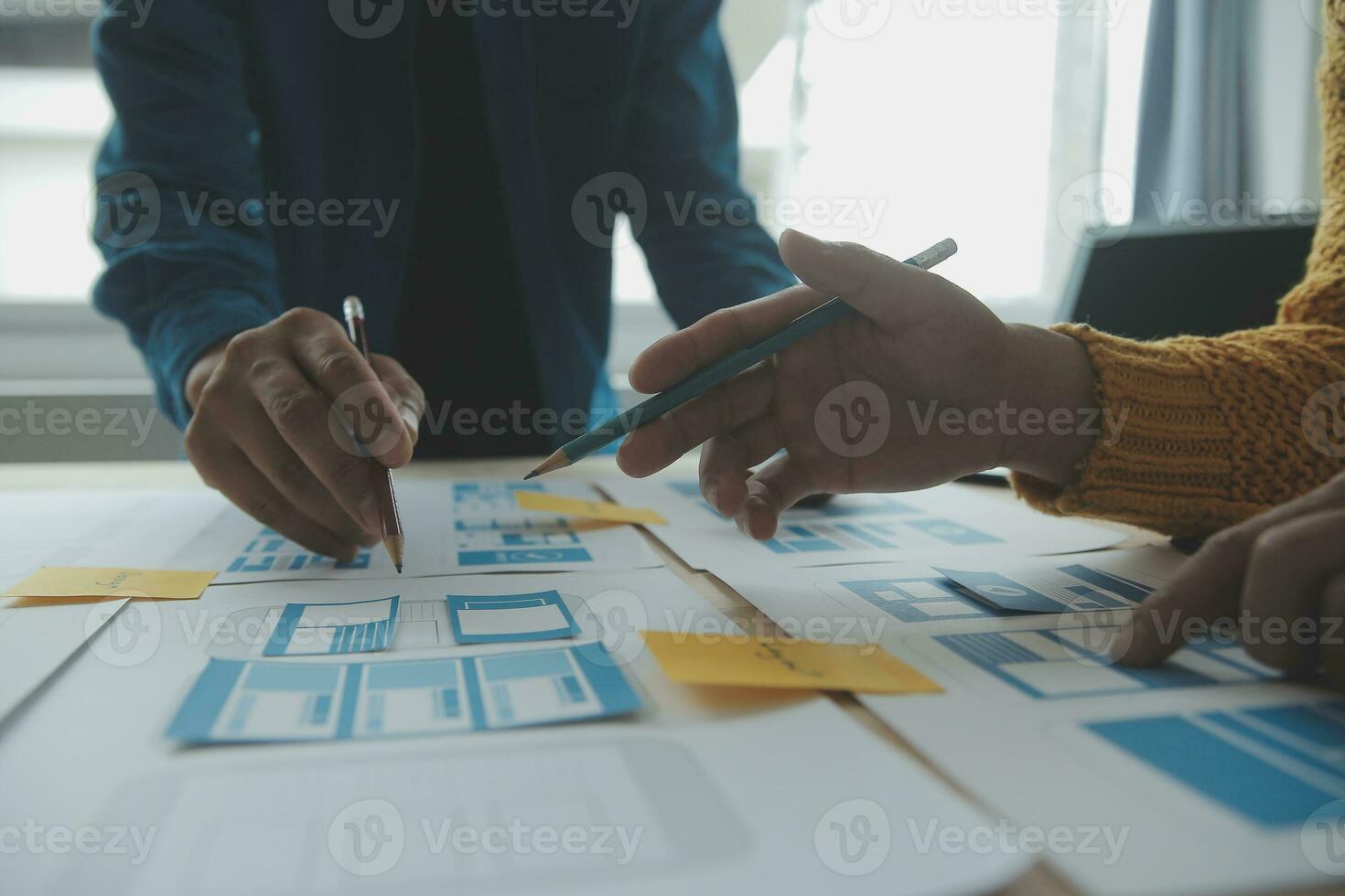 Close up ux developer and ui designer brainstorming about mobile app interface wireframe design on table with customer breif and color code at modern office.Creative digital development agency photo